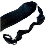 Jet black 100% human hair ponytail extension from THE HAIR PUSHER PREMIUM LUXE HAIR, showcasing smooth, shiny hair ready to wear.